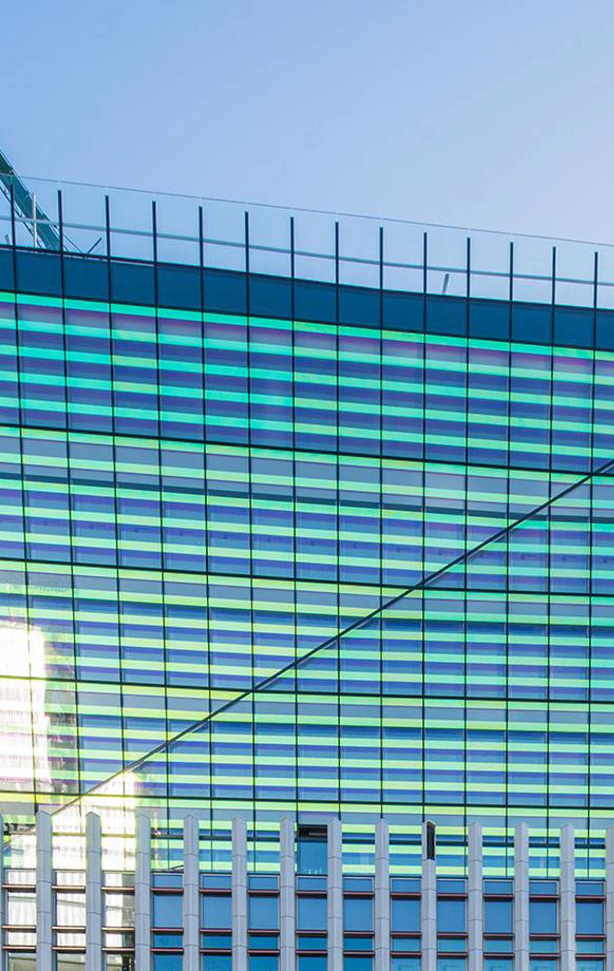 Exterior view of Fen Court in London, showcasing its modern design with a glazed 'crown' and striking facade that reflects sunlight in multiple colours.