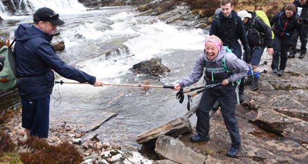 Colleagues crossing river during Rannoch Moor trek