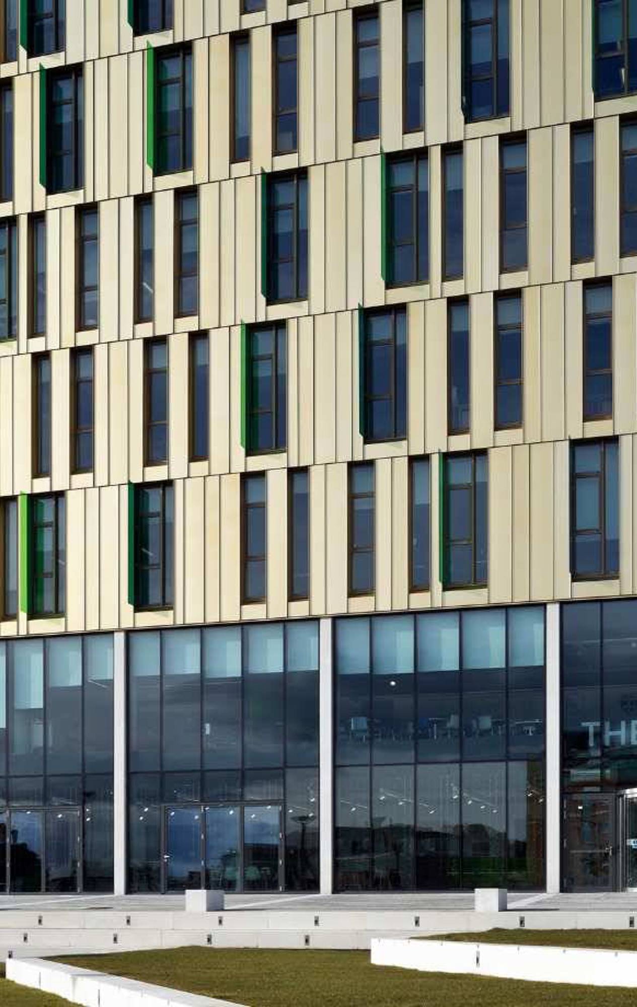Exterior view of The Core at Newcastle University, a seven-story building featuring green living walls and a modern design